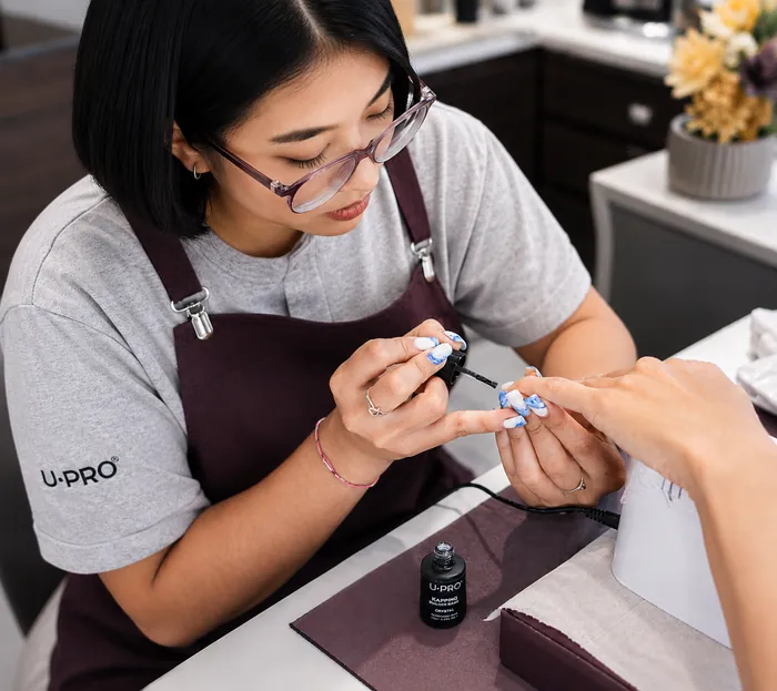 Nail artist applying colorful polish during a salon service