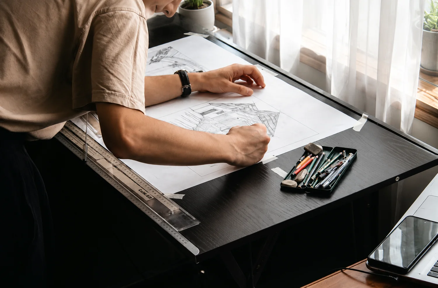 Architect developing a technical drawing at a drafting table with precision tools