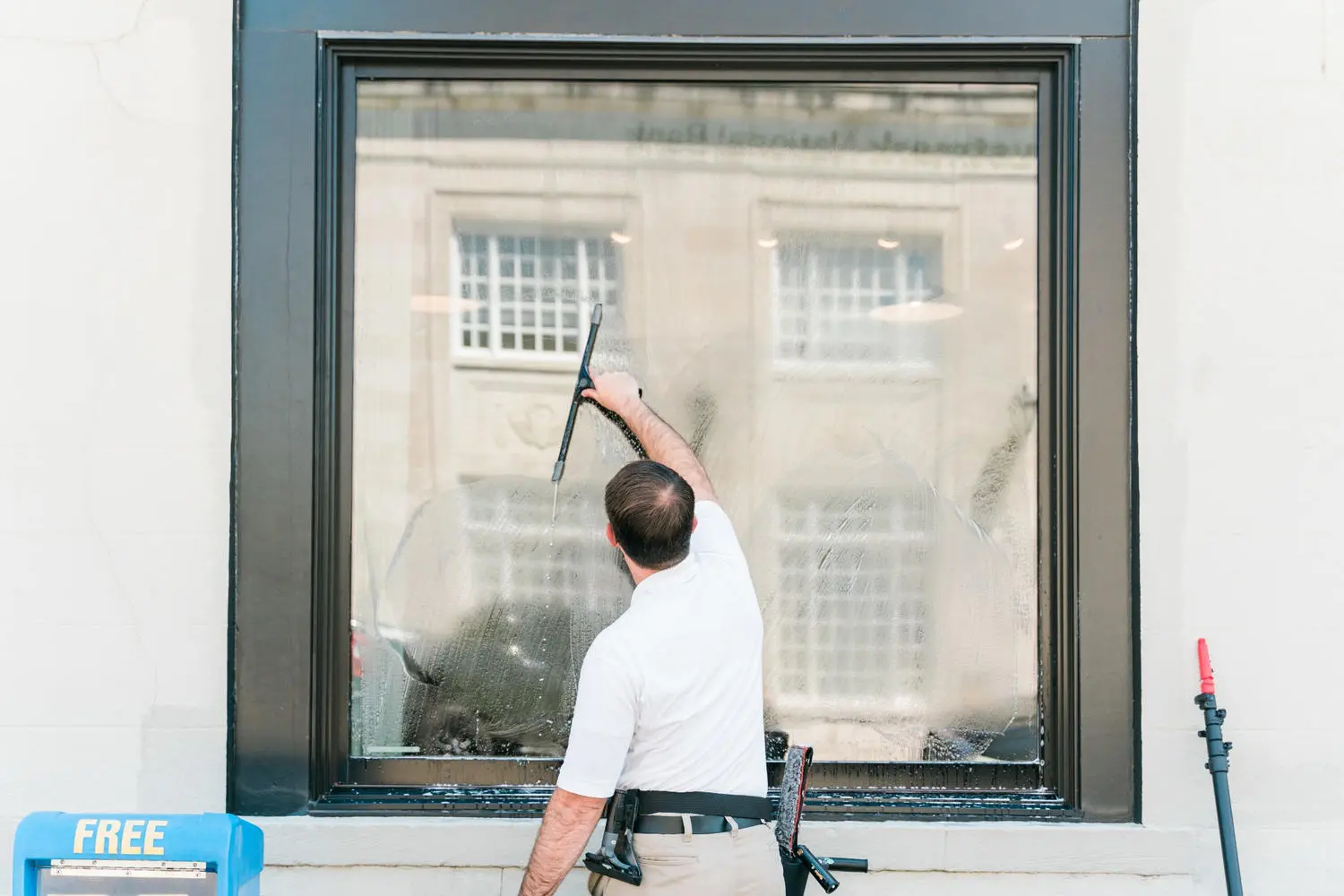 Craig cleaning a wet commercial storefront window