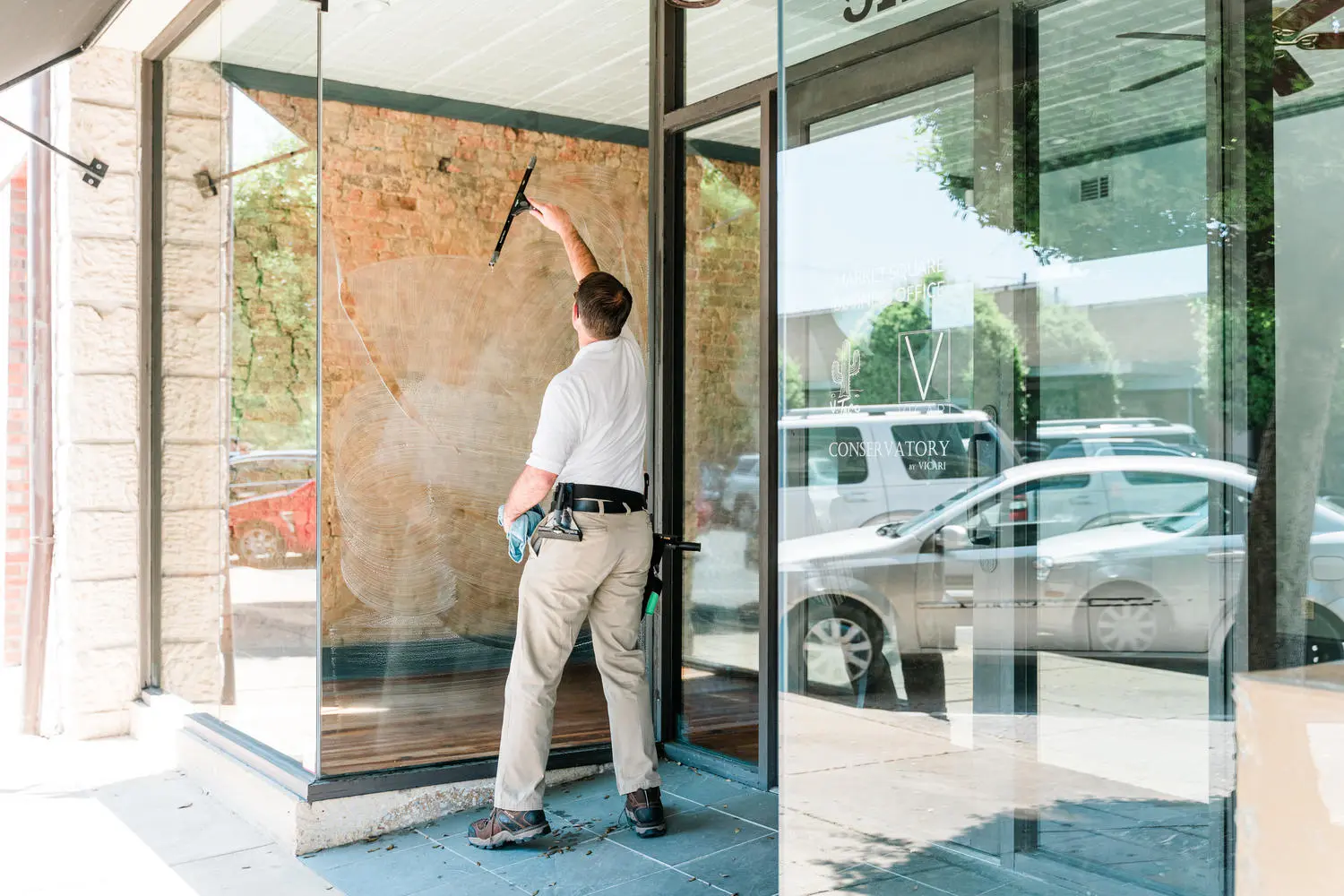Craig cleaning a large glass storefront by hand