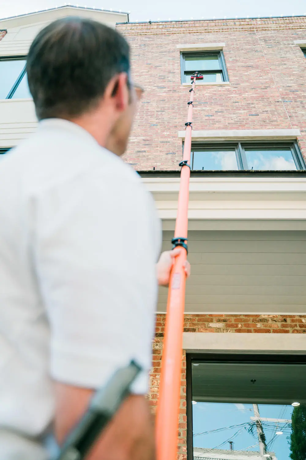 Craig cleaning a large commercial window with a professional squeegee