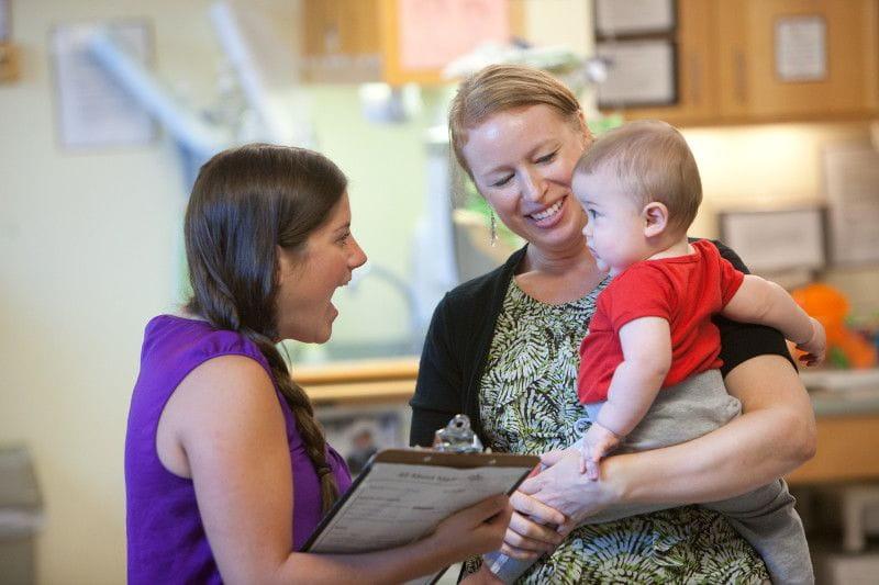 Daycare worker speaking with parent during pediatric care enrollment