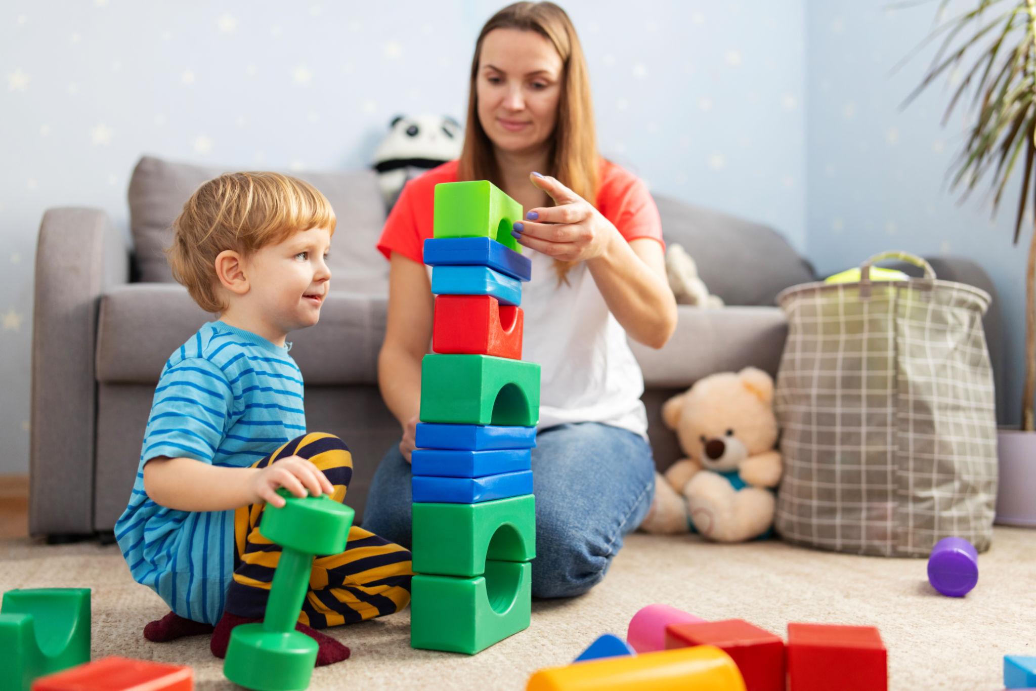 Caregiver and child playing with blocks in a nurturing setting
